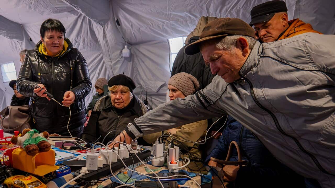 People charge their phones at one of the heated tents called points of invincibility, government-built help stations, during a total blackout in Chernihiv, Ukraine