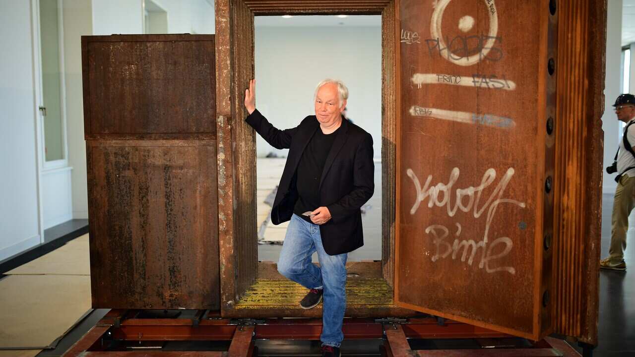 The founder of Tresor club Dimitri Hegemann poses in front of the former Tresor club door at the construction site of the Humboldt Forum museum in Berlin.
