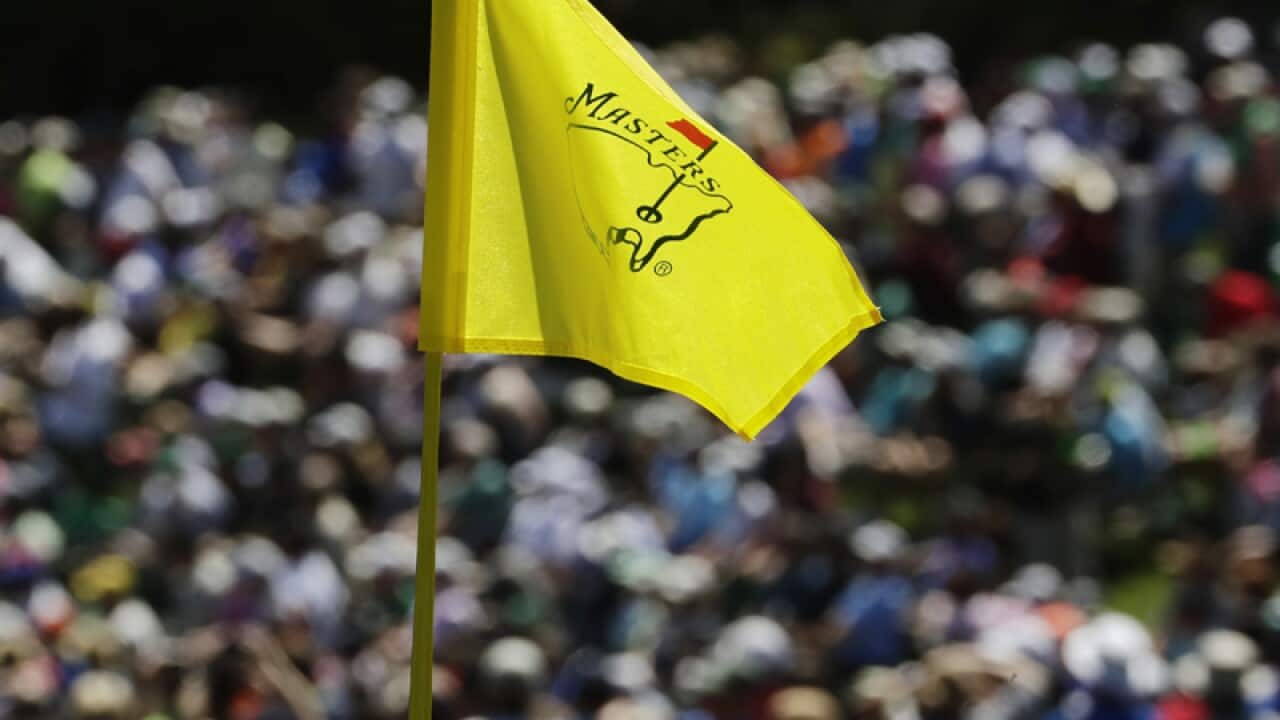 A golf pin flag flutters in the wind during the Masters tournament