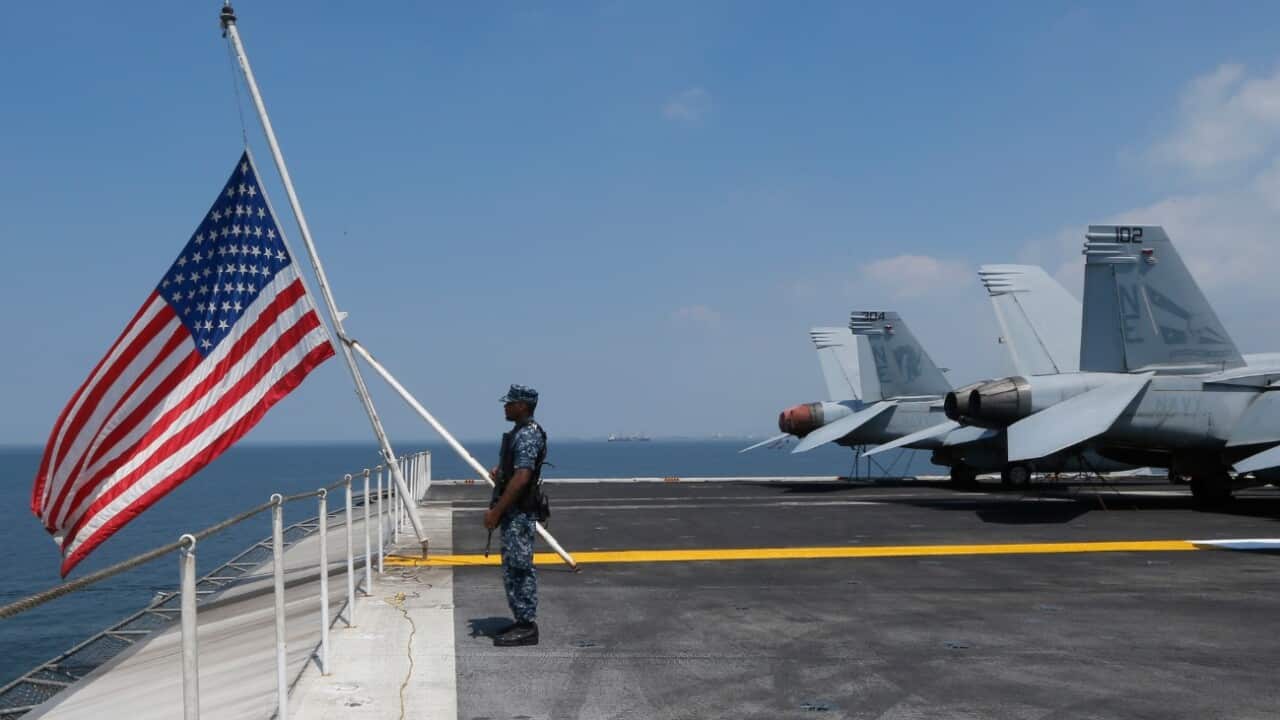 File: A US Marine stands guard on the flight deck of the US aircraft carrier USS Carl Vinson aircraft carrier anchors off Manila, Philippines