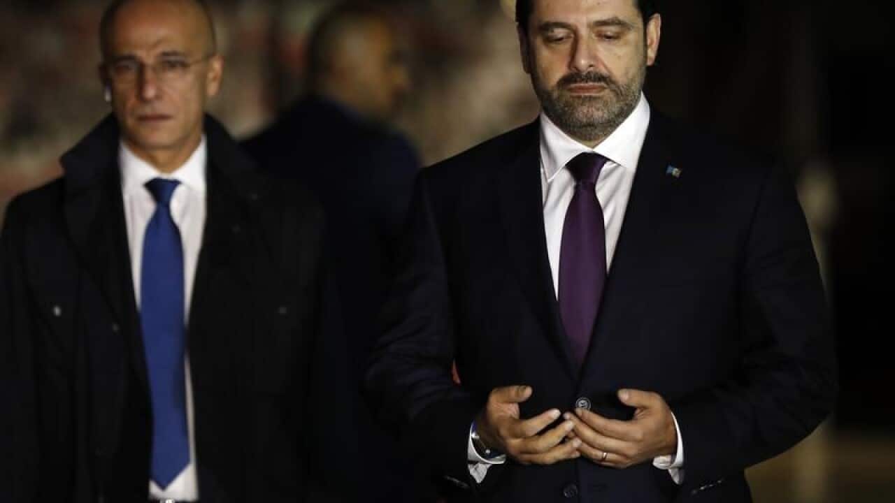 Lebanese Prime Minister Saad Hariri prays over his father's grave