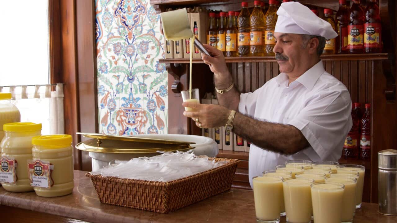 Shop owner pouring Boza (a traditional Turkish energy drink) into a glass in his shop, photographed in IstanbulBoza is a malt beverage with a low alcohol content that’s made by fermenting wheat or millet. It has a smoothie-like consistency but could also