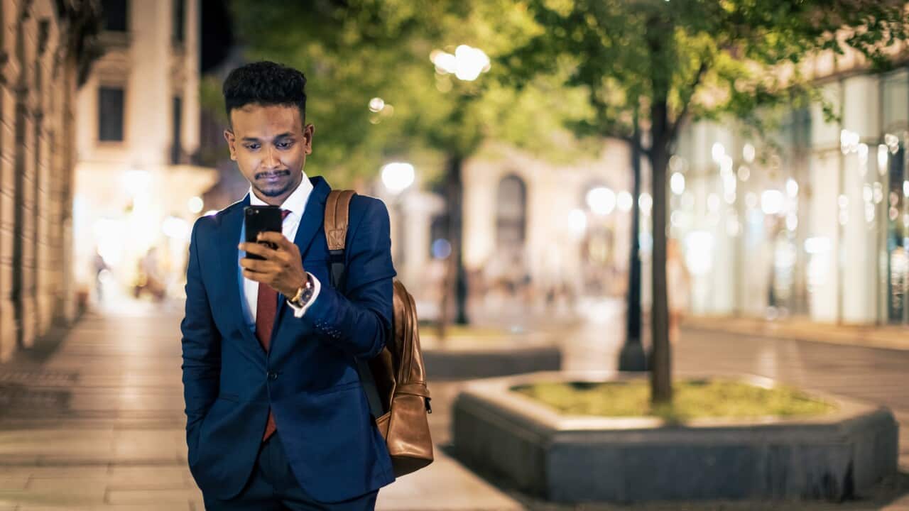 Businessman texting and walking home after work