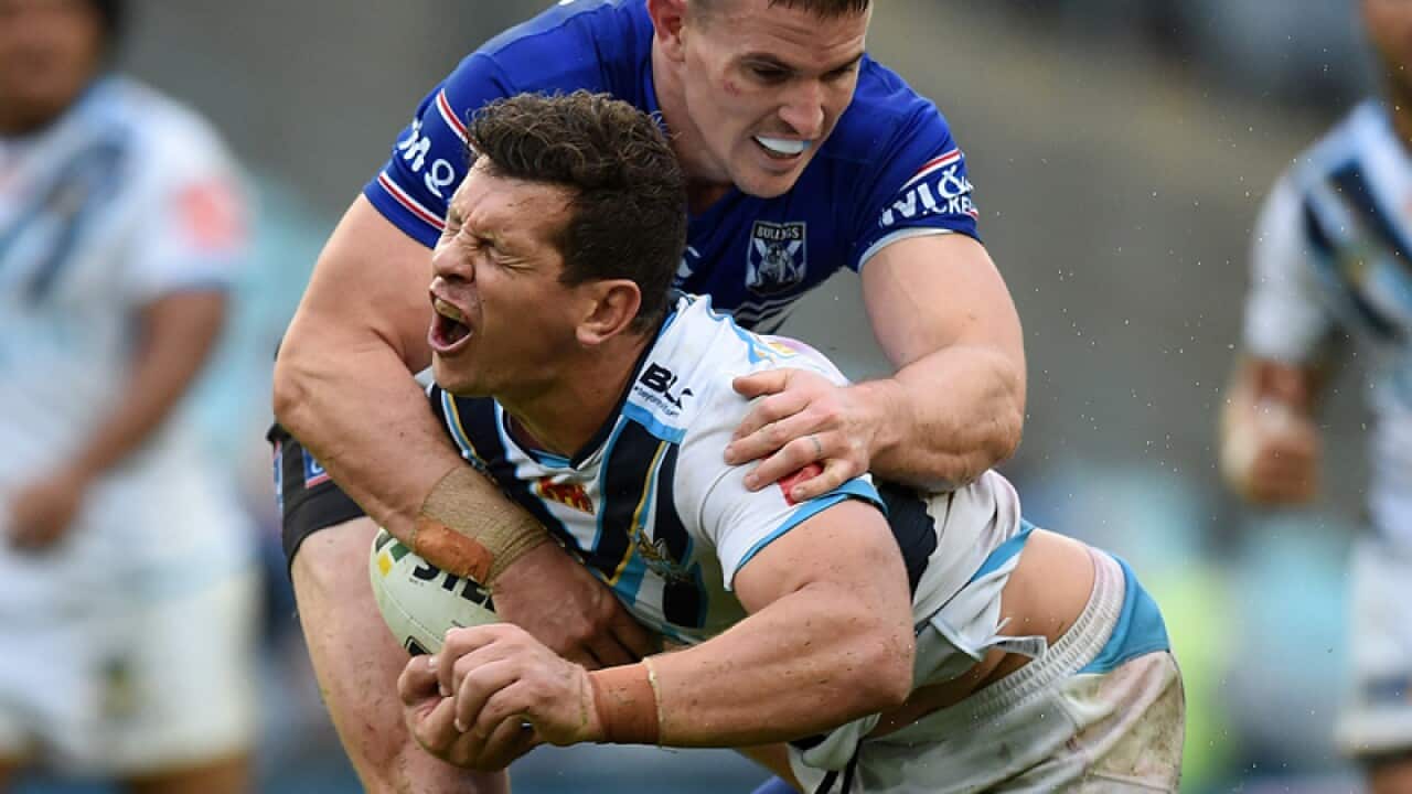 Greg Bird of the Titans is tackled by Tim Browne of the Bulldogs