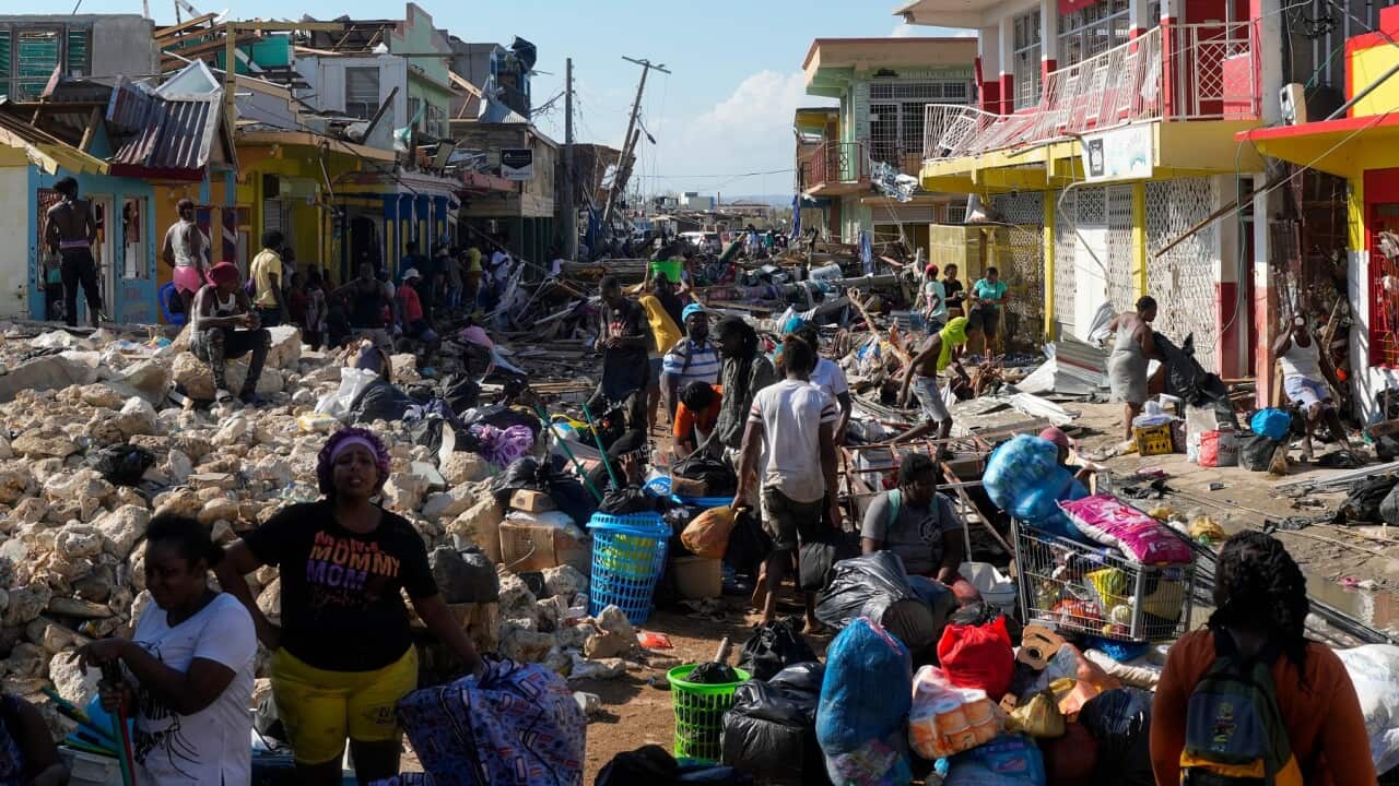 People survey the damage from Hurricane Melissa.
