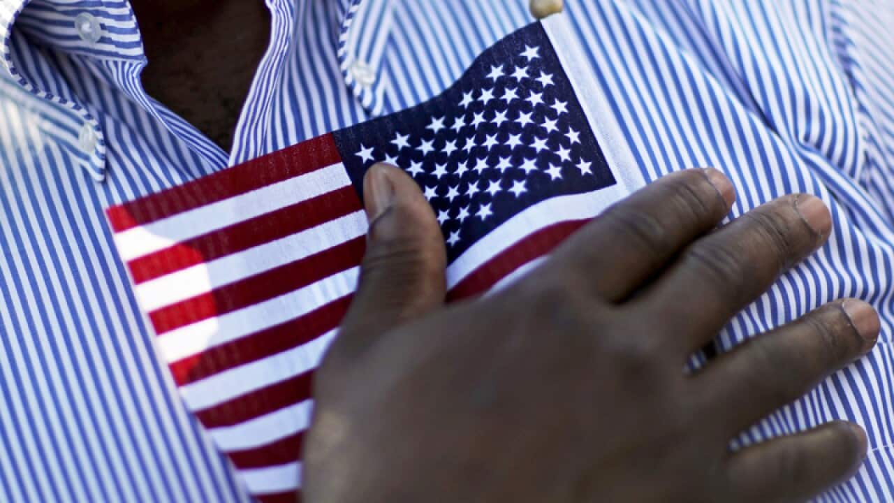 A candidate for citizenship holds an American flag