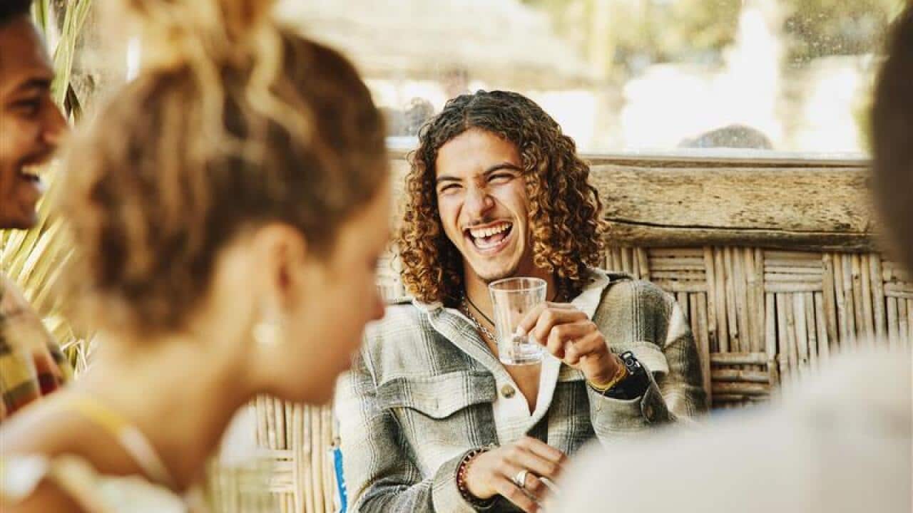 A man holds an empty glass
