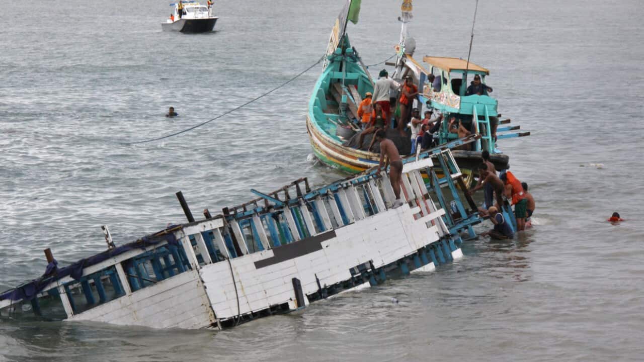 Rescuers check the wreckage of a people smuggler's boat seen half submerged after being towed near the coast of Puger village in East Java province in 2011. 