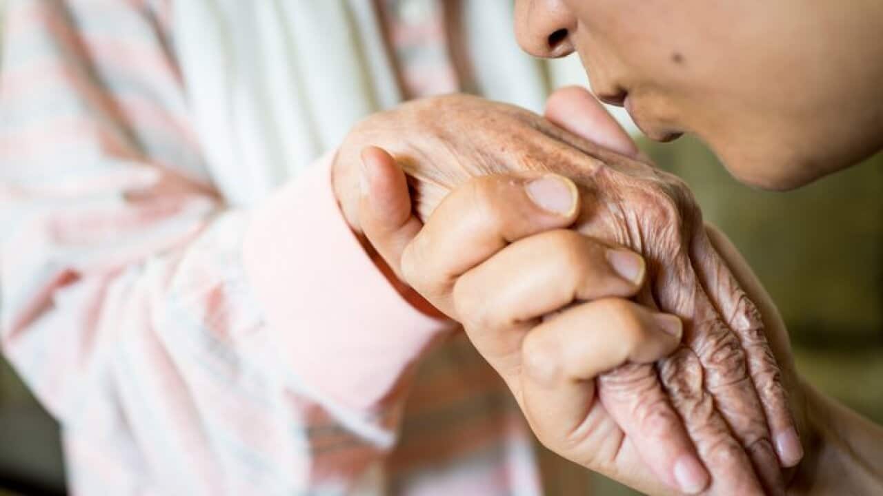 Muslim woman kissing hand of her old mother