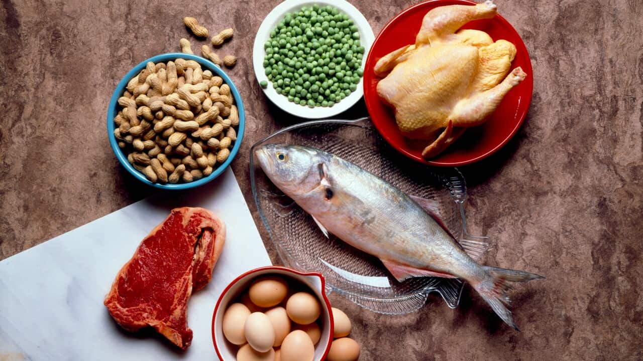 A kitchen bench with a variety of proteins such as steak, nuts, fish, eggs, chicken and peas.