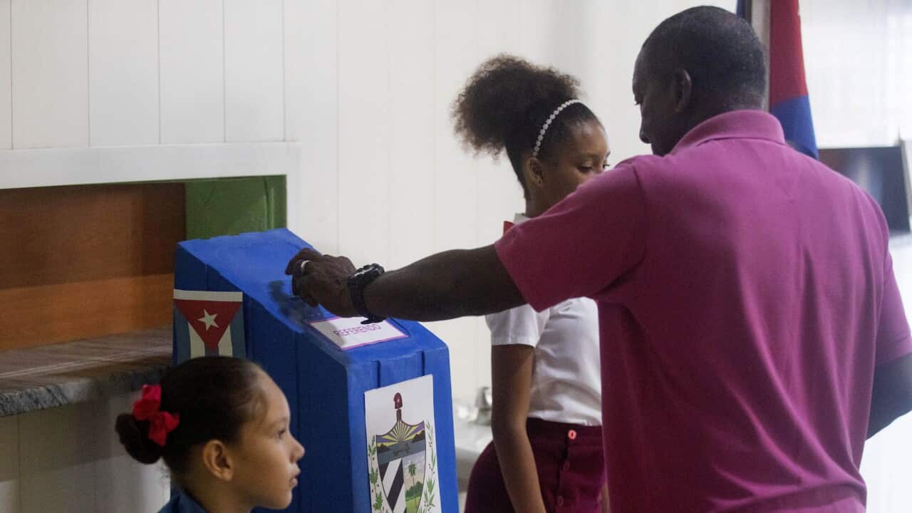 A man puts a vote in a ballot box