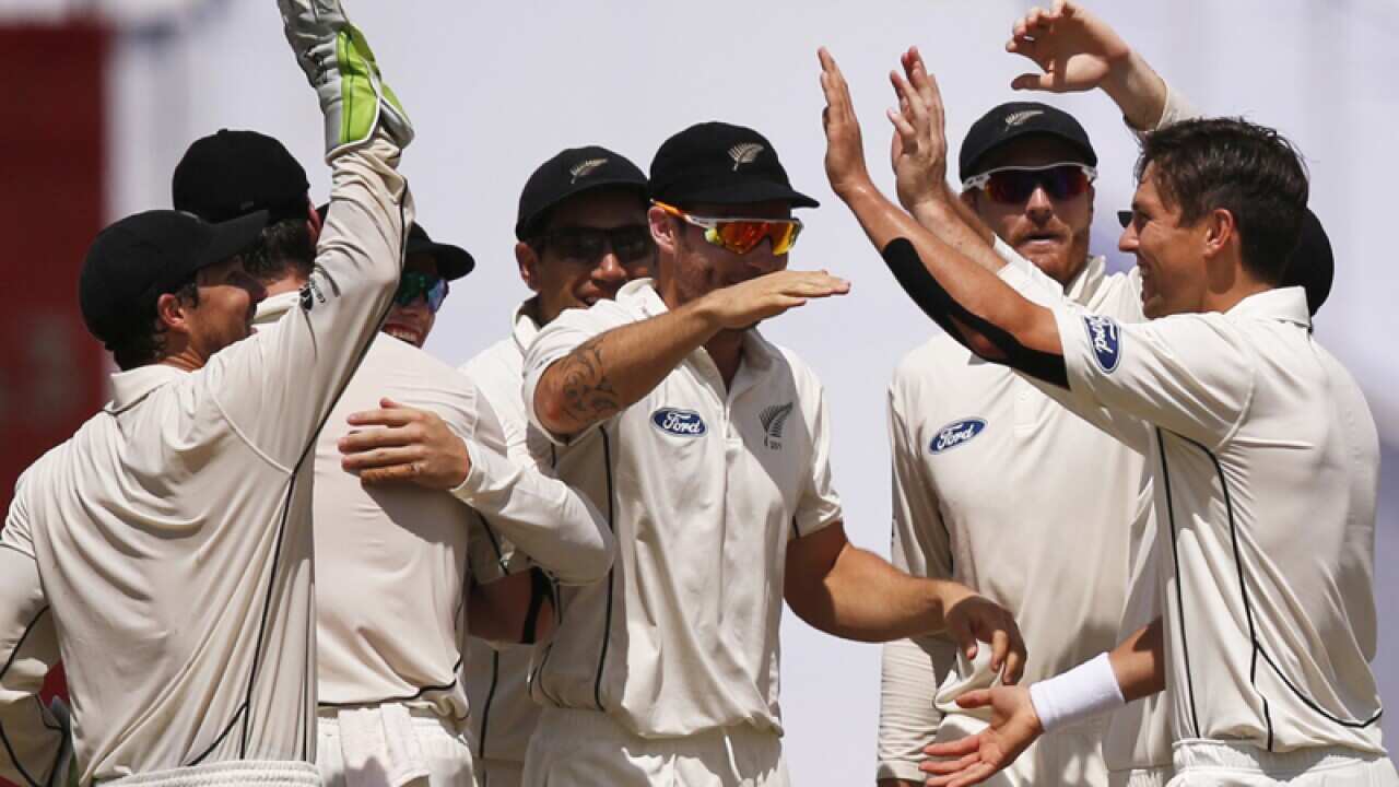 New Zealand's Trent Boult, right, celebrates with team mates