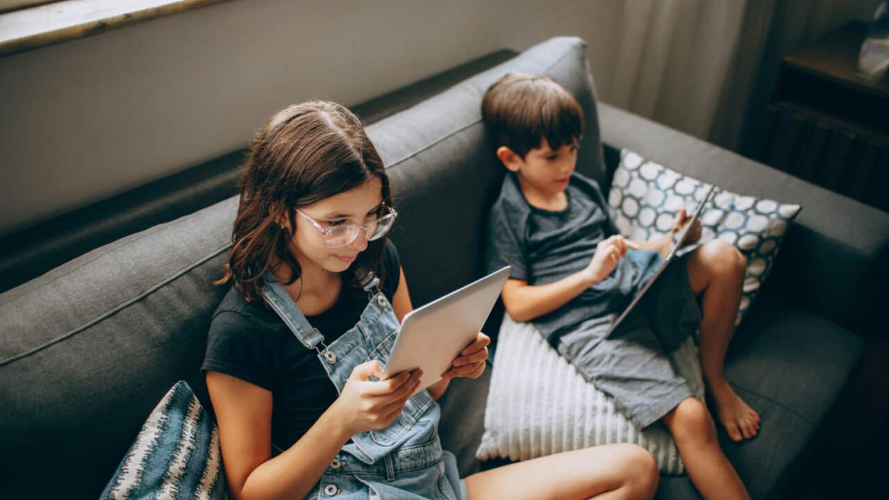children using gadget on couch