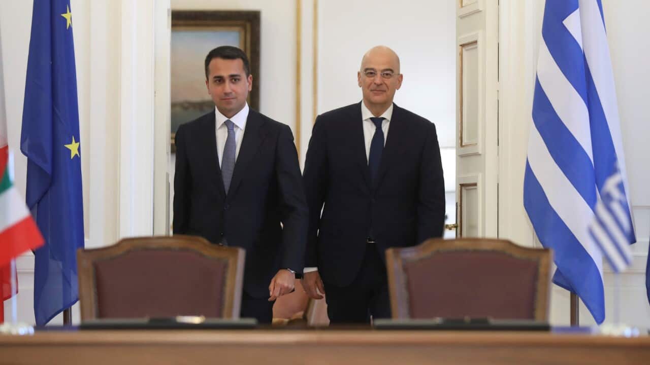 Greek Foreign Minister Nikos Dendias, right, and his Italian counterpart Luigi Di Maio arrive to sign an agreement following their meeting , in Athens.