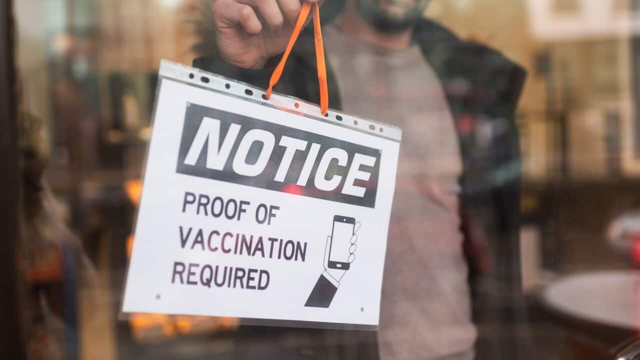 Man hanging information sign at door entrance