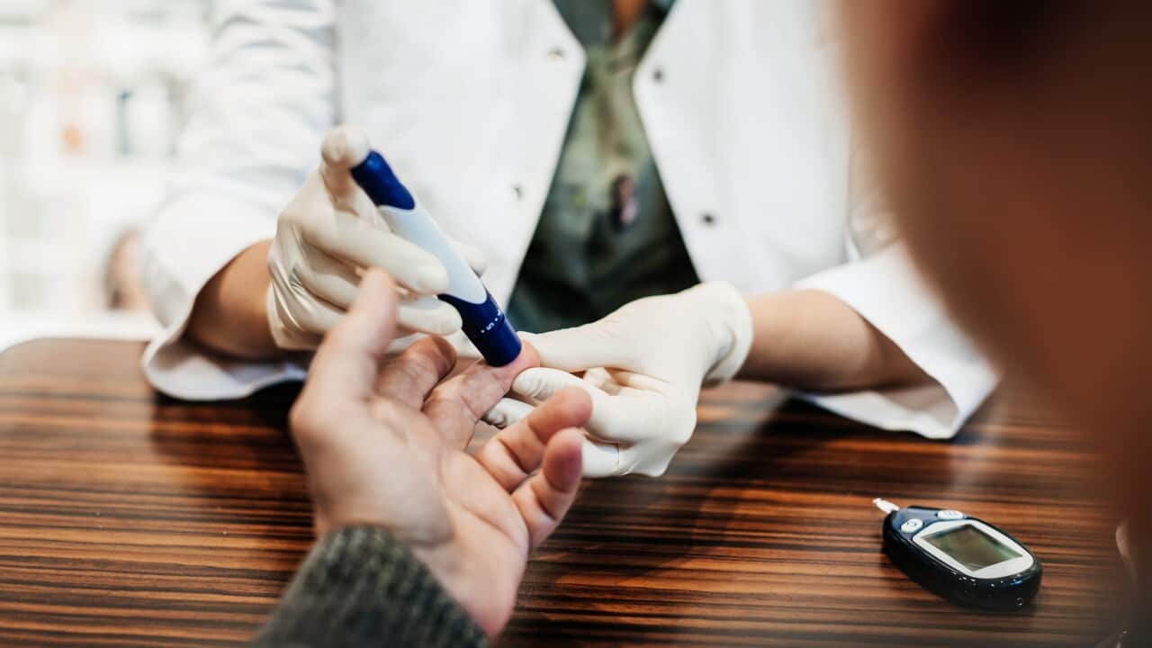 A doctor checking a diabetes patient's blood sugar levels