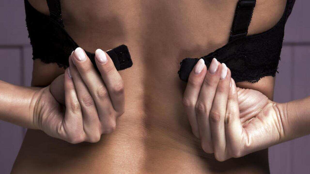 The young woman taking off her bra