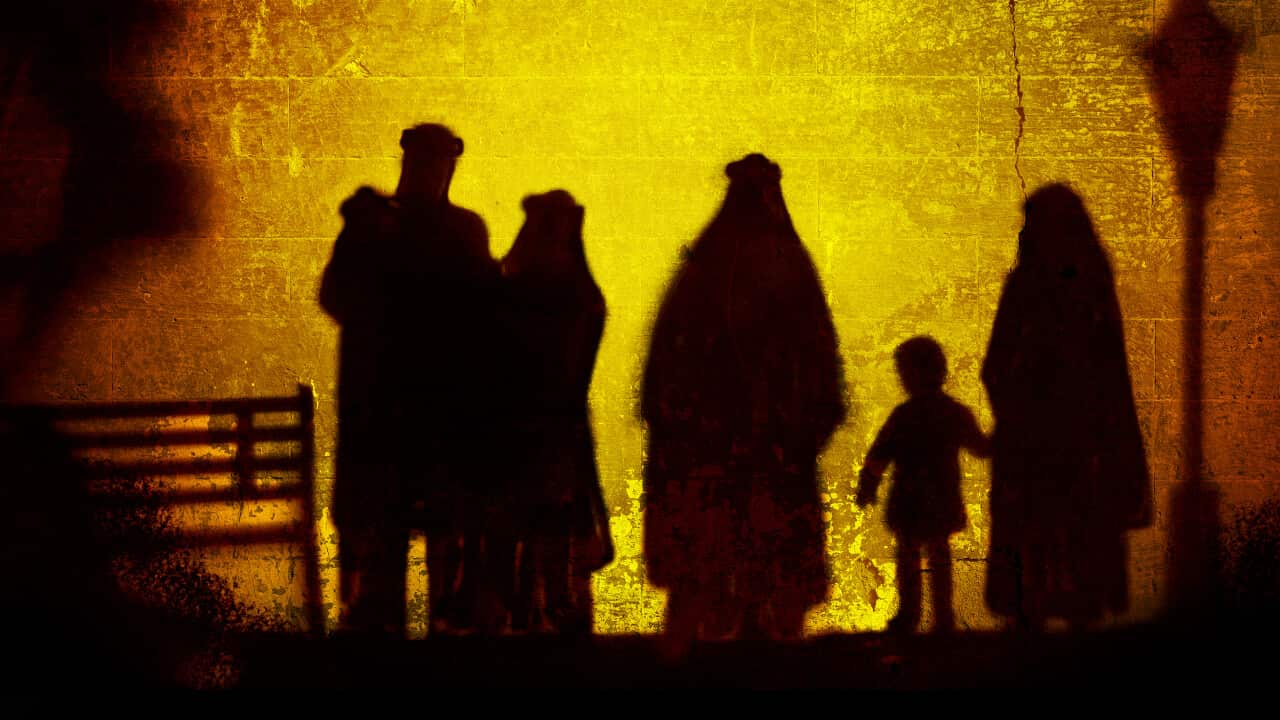 The outlines of people against an orange and yellow backdrop.