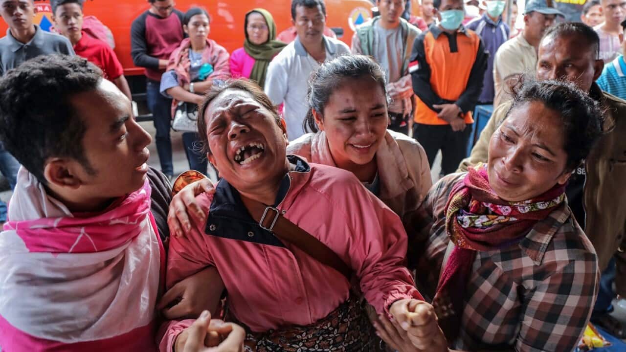 Relatives of the victims of a ferry that sank in Lake Toba, cry as they wait for news.