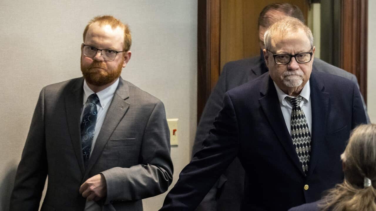 Two men in suits entering a courtroom