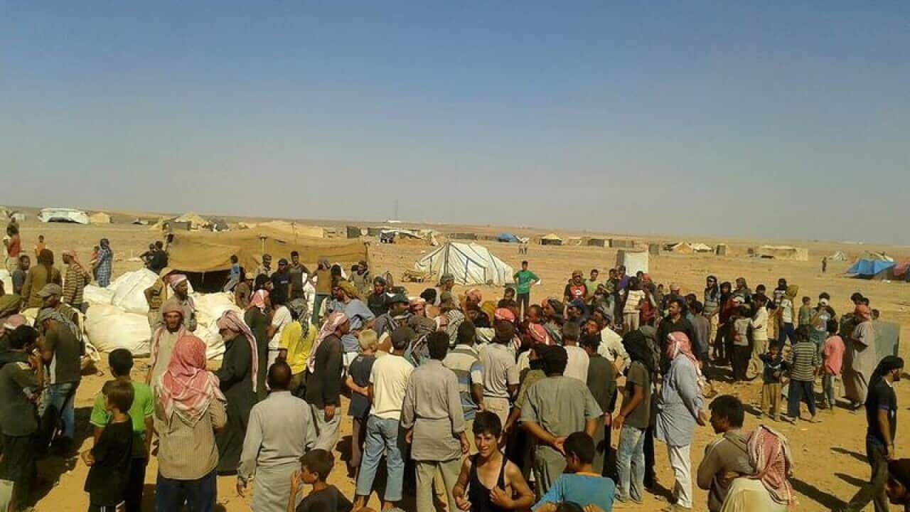 A file image of refugees lining up for food in the Rukban camp