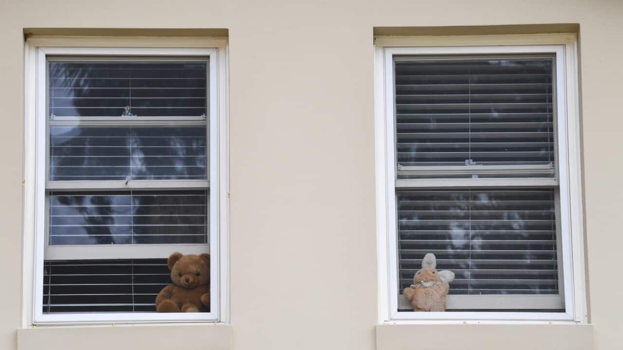 Stuffed toys in the windows of a house.