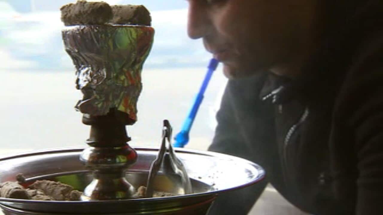 A man smokes shisha in a Melbourne cafe.
