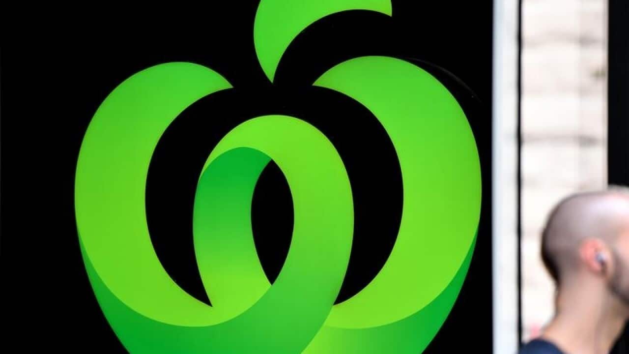 Woolworth's W logo with blurred head and shoulder of passing man.