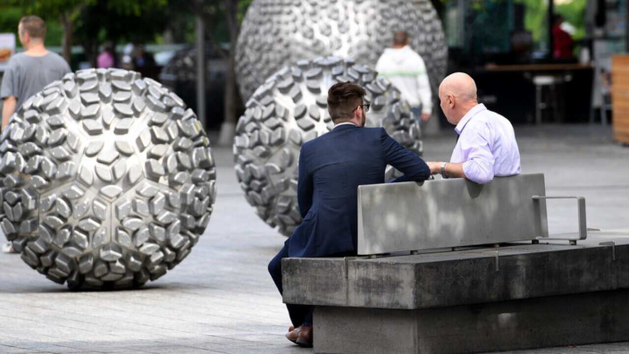 Two men chat in Brisbane Square