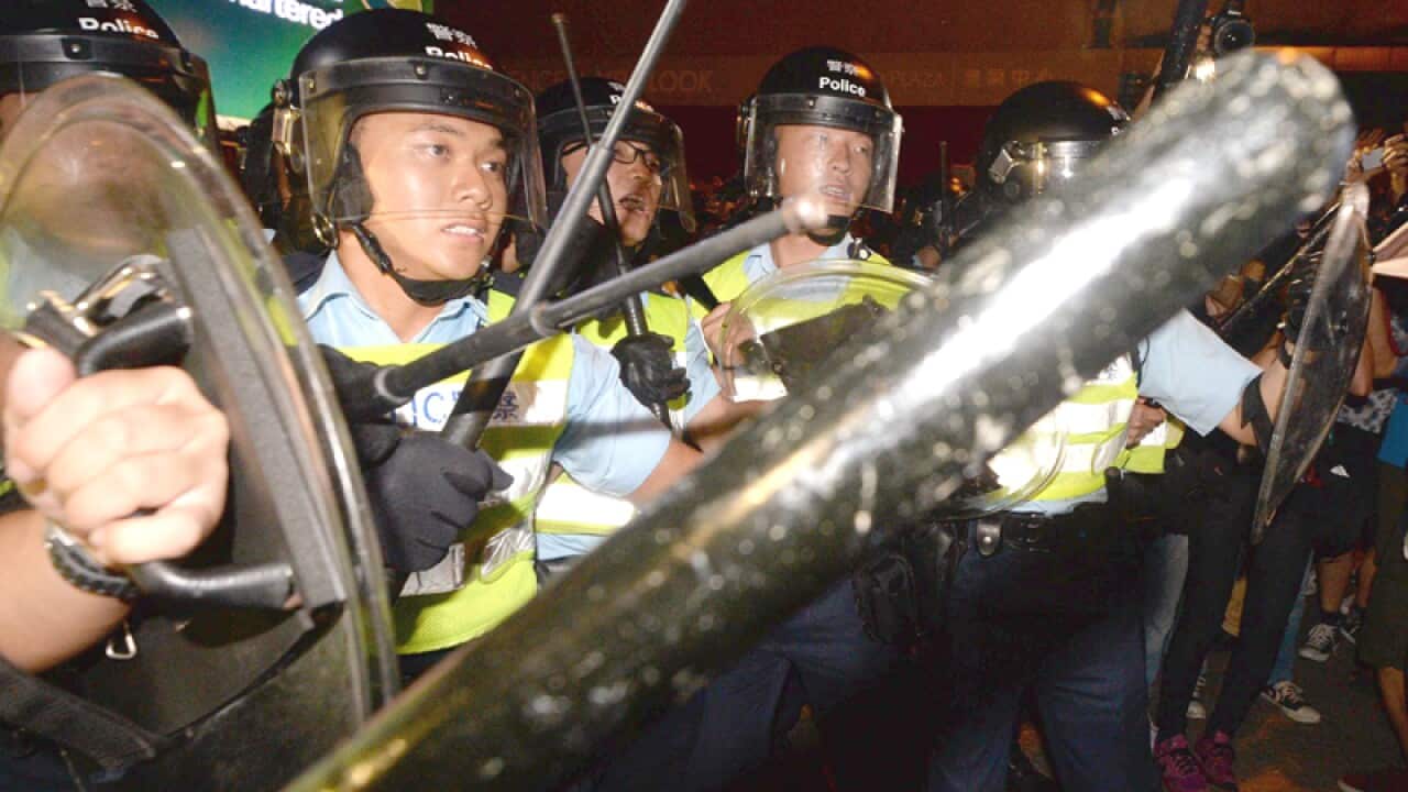 Police officers with batons confront pro-democracy protesters, China