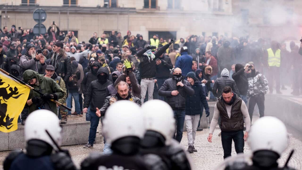 Protesters face off against the police during an anti-migrant demonstration outside of EU headquarters in Brussels