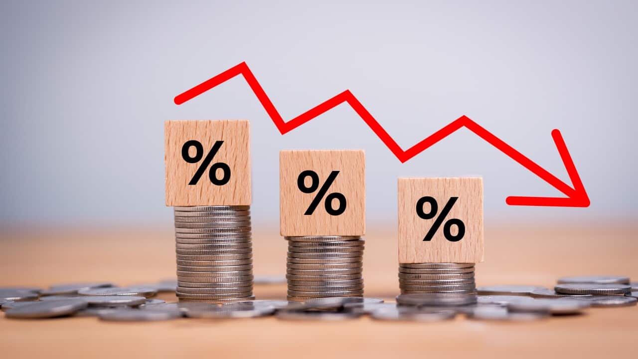 Percentage sign on wooden cubes with Stack of coin bar chart and red graph trending downwards on white background. Economy recession crisis, inflation, stagflation, business and financial loss concept