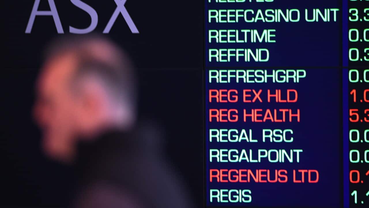 A man in front of the Australian Stock Exchange board, Sydney