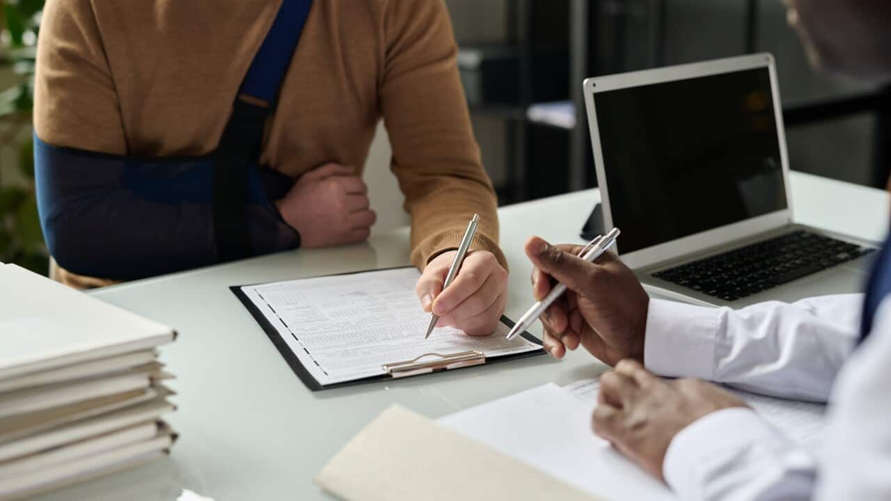 Close up of man filling in medical insurance form