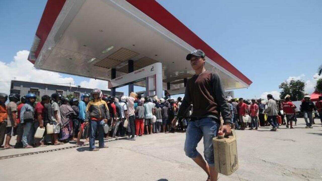 People queue for fuel at a petrol station after a earthquake and tsunami hit Palu, Central Sulawesi.