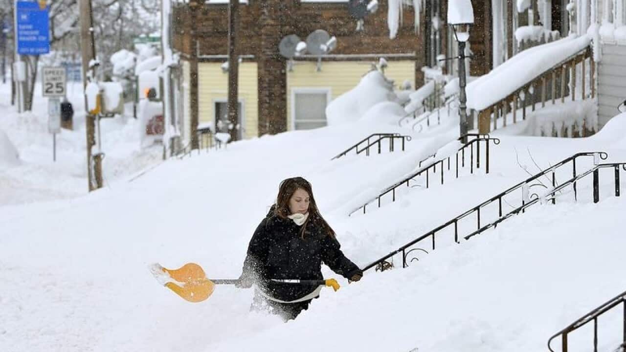 A woman shovels steps near her home in Erie, Pennsylvania
