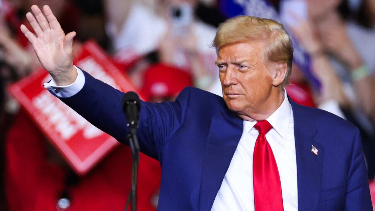 Donald Trump waving while on stage.