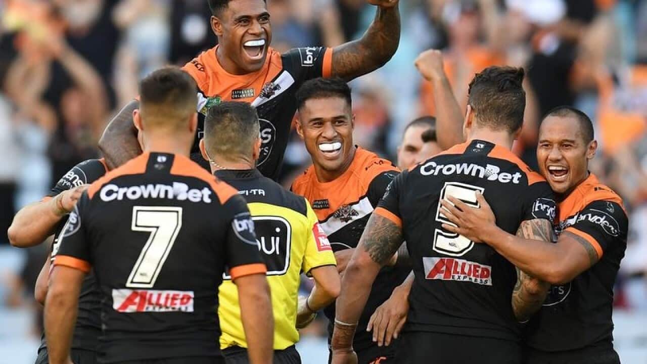 Wests Tigers players celebrate after their win