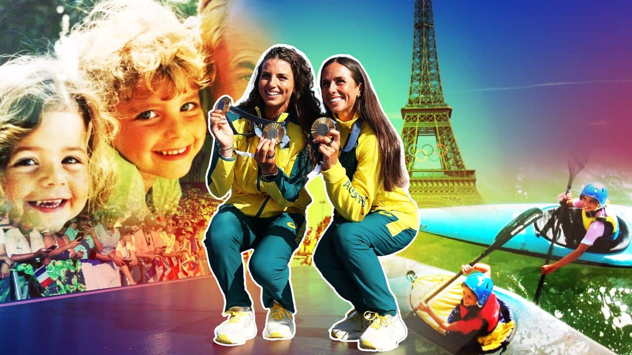 Olympic canoeists and sisters Jess Fox and Noémie Fox hold gold medals and smile in front of the Eiffel Tower in Paris.