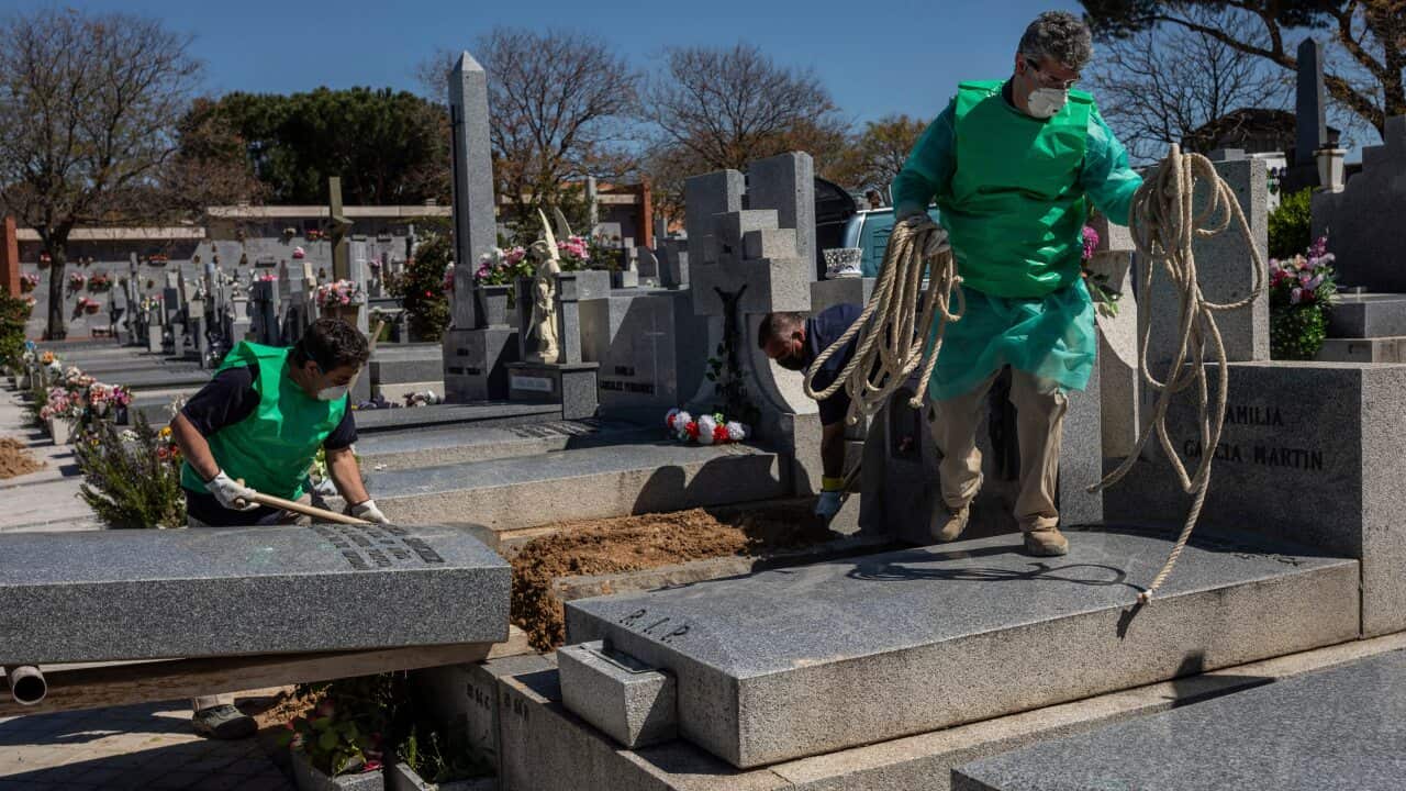 Undertakers wearing garbage bags as a safety mesure during the coronavirus outbreak work at cemetery in Madrid, Spain.