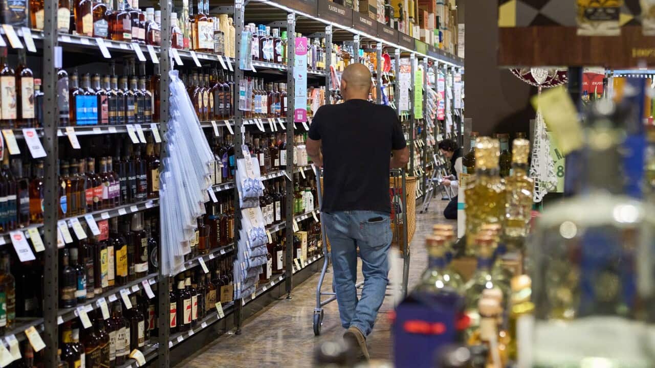 A person shops for alcohol at a bottle shop