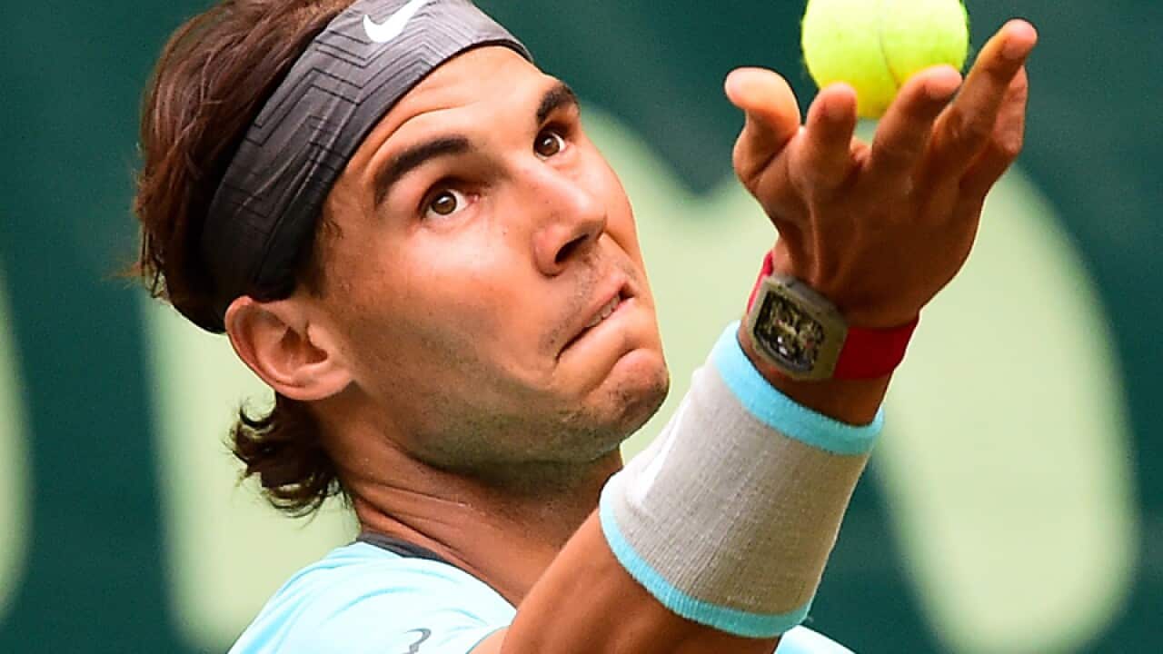Rafael Nadal serves.