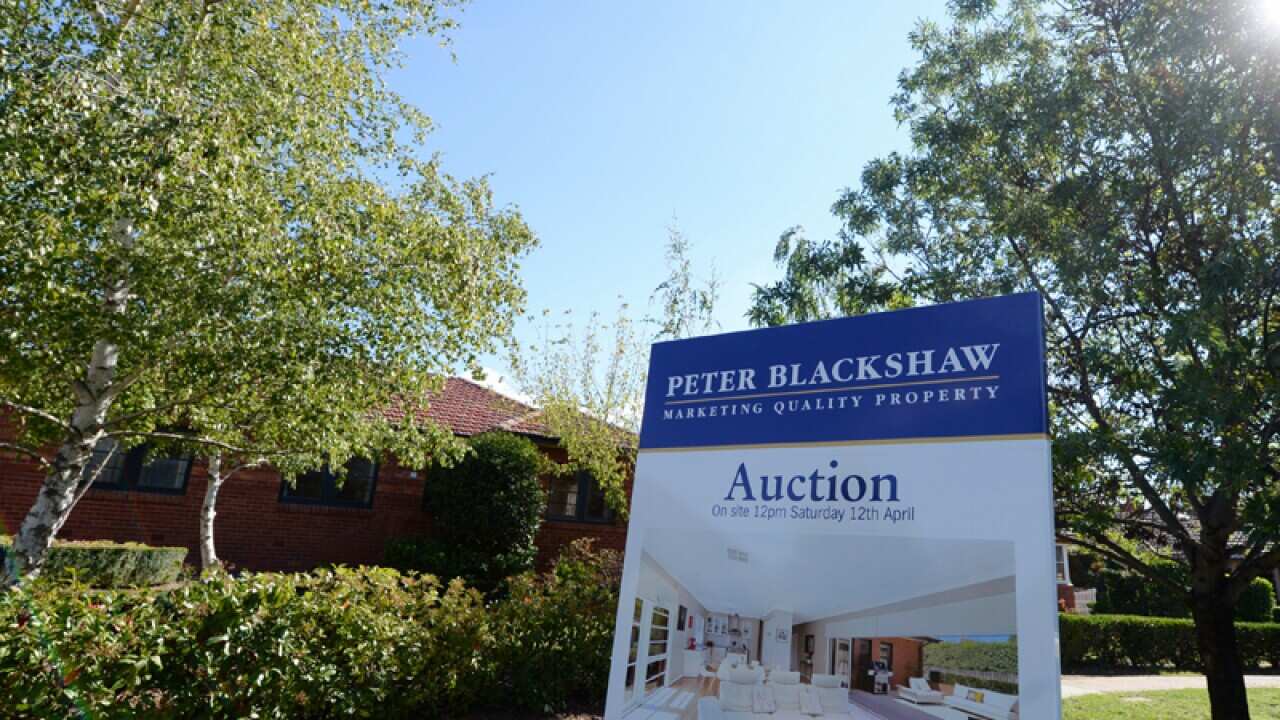 An auction sign is seen in front of a house.