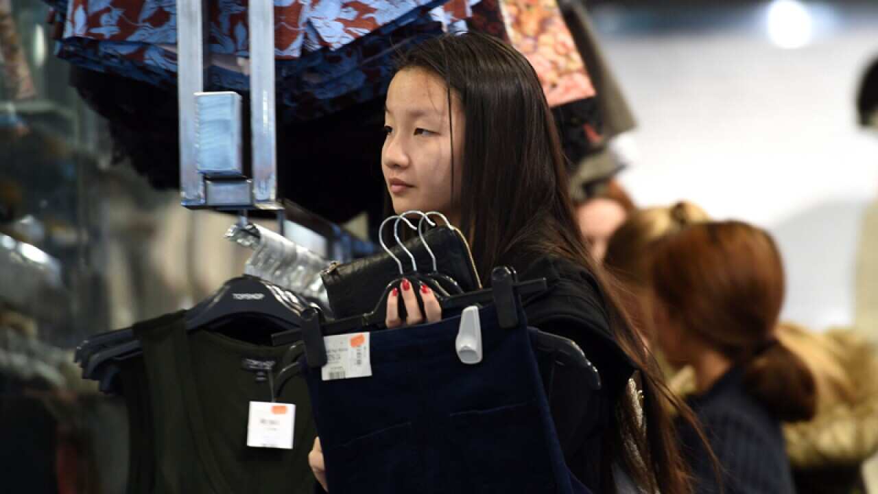 A shopper looks at clothes in a store