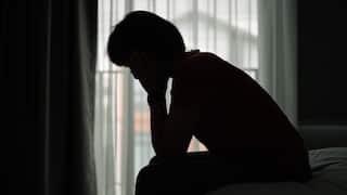 A woman sitting on the edge of a bed.