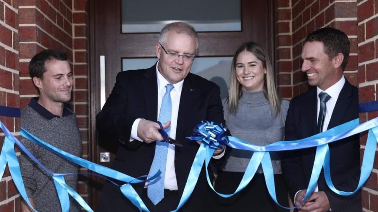 Scott Morrison cuts the ribbon at the new home of first home owners.