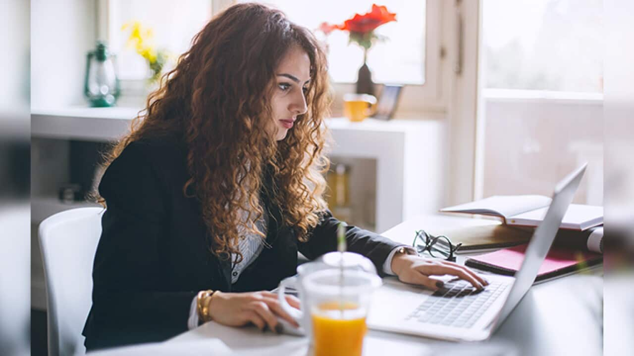 Stylish woman working, using laptop, mobile phone, taking notes and searching the internet.