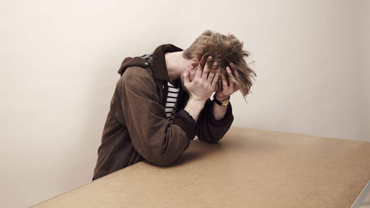 Portrait of man with his head in his hands