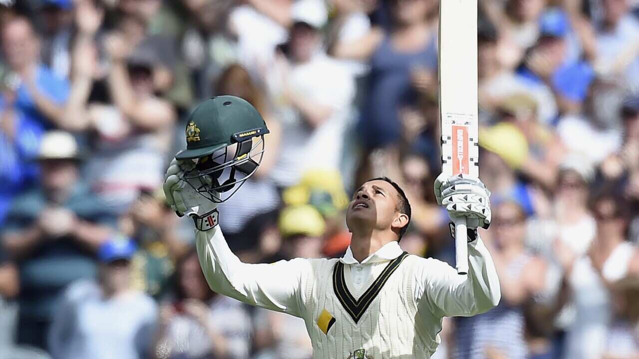 Australia's Usman Khawaja celebrates scoring a century against the West Indies during their cricket test match in Melbourne