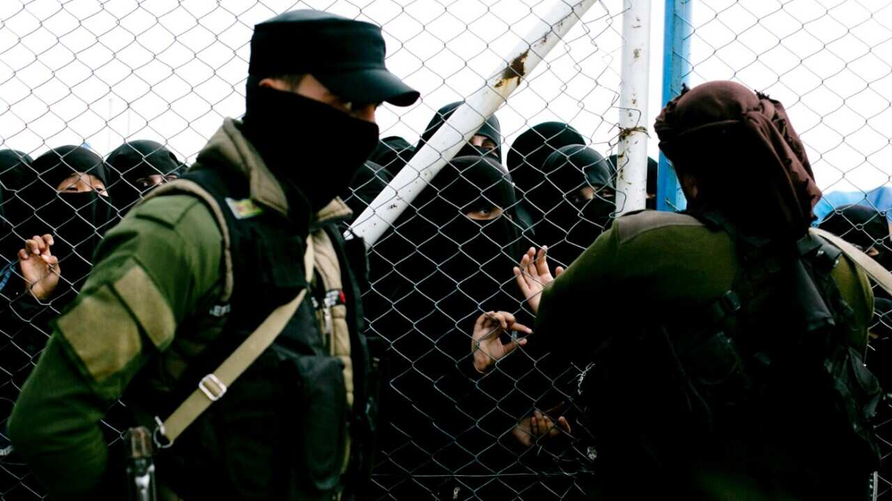 File photo of guards speaking to women at the Al-Hawl camp 